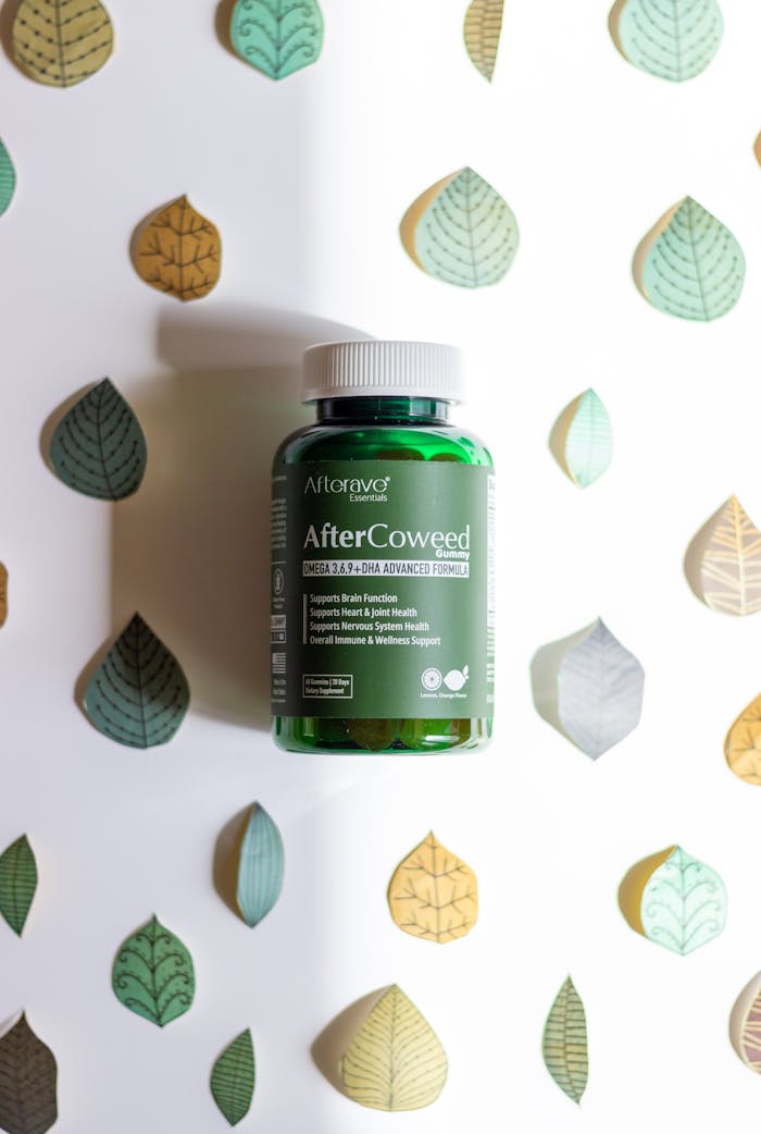 services-03 Green bottle of dietary supplement with leaf designs on a white background.